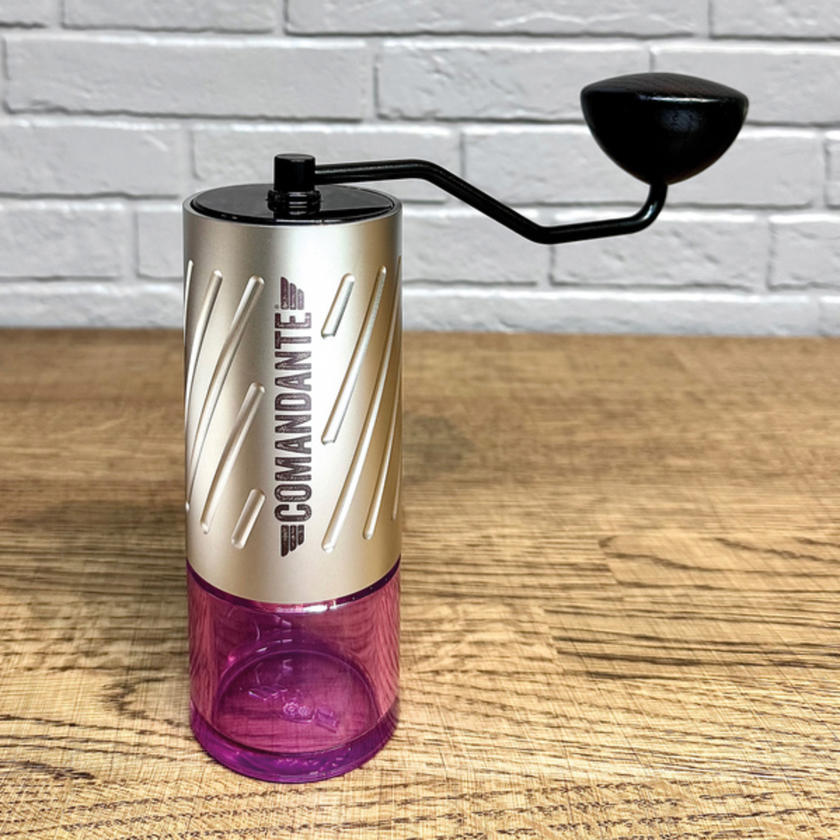 Comandante C60 Baracuda Handkaffeemühle Velvet Steel mit Bohnenbehälter in Pink auf einer Küchenplatte