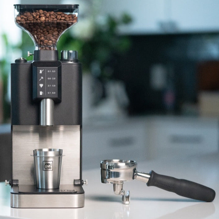 HeyCafé Jack Allround Grinder Elektrische Kaffeemühle schwarz mit Siebträgerhalter daneben